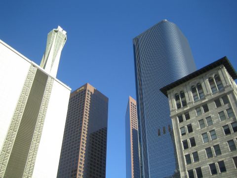 1968 Ford Mustang - A view looking up at various skyscrapers in a city, set against a bright blue sky.