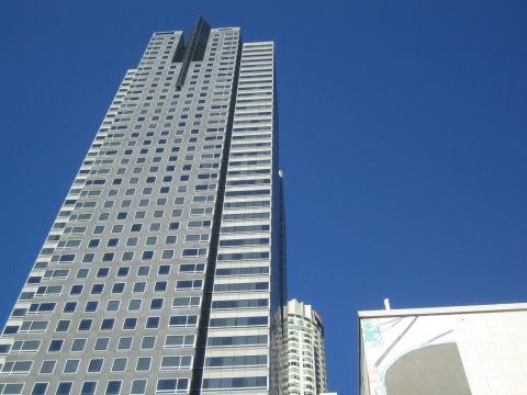 1968 Ford Mustang - A view looking up at several tall buildings, including a prominent skyscraper, against a bright blue sky.