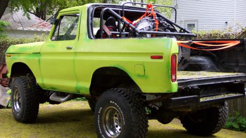 1978 Ford Bronco - This modified 1978 Ford Bronco features a roll cage and aggressive off-road tires, viewed from the rear three-quarter angle.