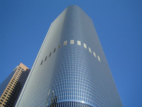 1968 Ford Mustang - Modern architecture dominates the skyline under a bright blue sky.