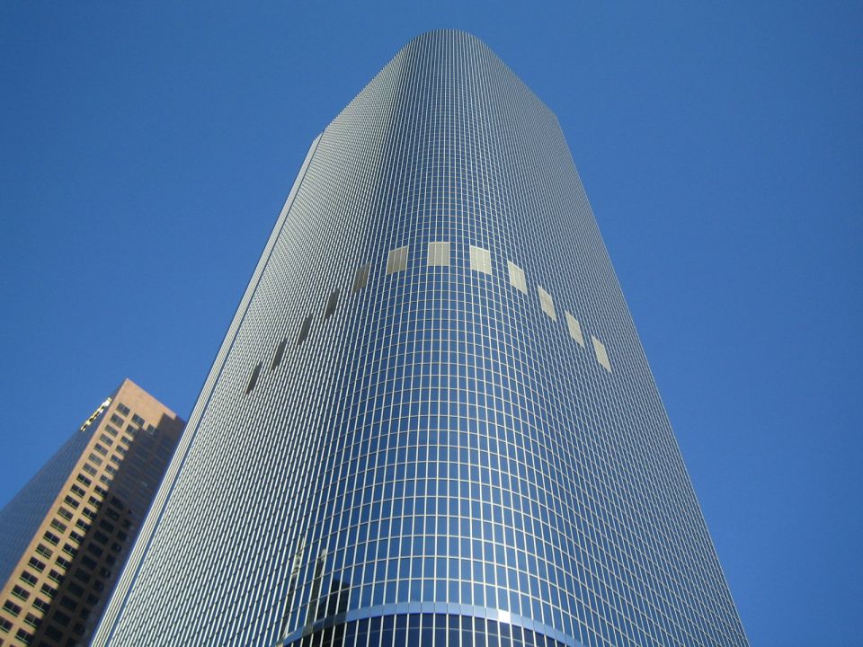 Two modern skyscrapers against a clear blue sky, viewed from below
