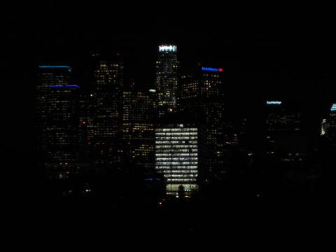 1968 Ford Mustang - A nighttime view of a city skyline, numerous illuminated skyscrapers against the dark sky.
