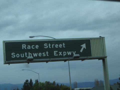 1990 Ford Bronco - Green overhead highway guide sign reading Race Street / Southwest Expwy with an up-right arrow against a gray cloudy sky.