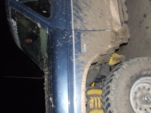 1986 Ford Bronco - This blue SUV is heavily covered in mud, obscuring most identifying details and making its year and model uncertain.