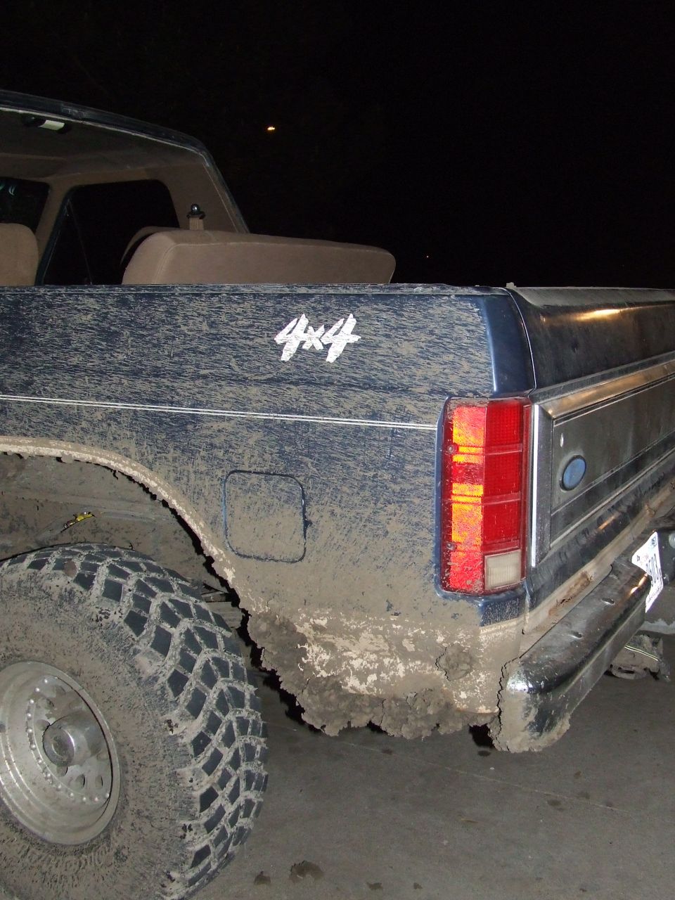 Mud-covered 1986 Ford Bronco rear quarter panel with 4x4 decal
