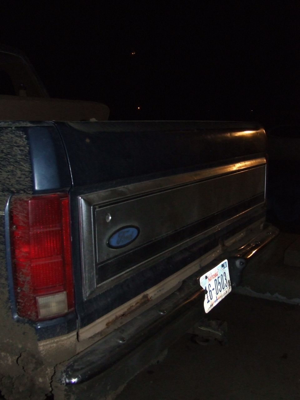 Dark blue pickup truck rear with chrome trim and a license plate reading 16-0503