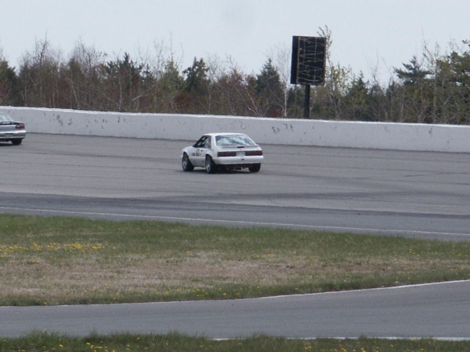 White Fox Body Mustang race car on track, another car visible in distance