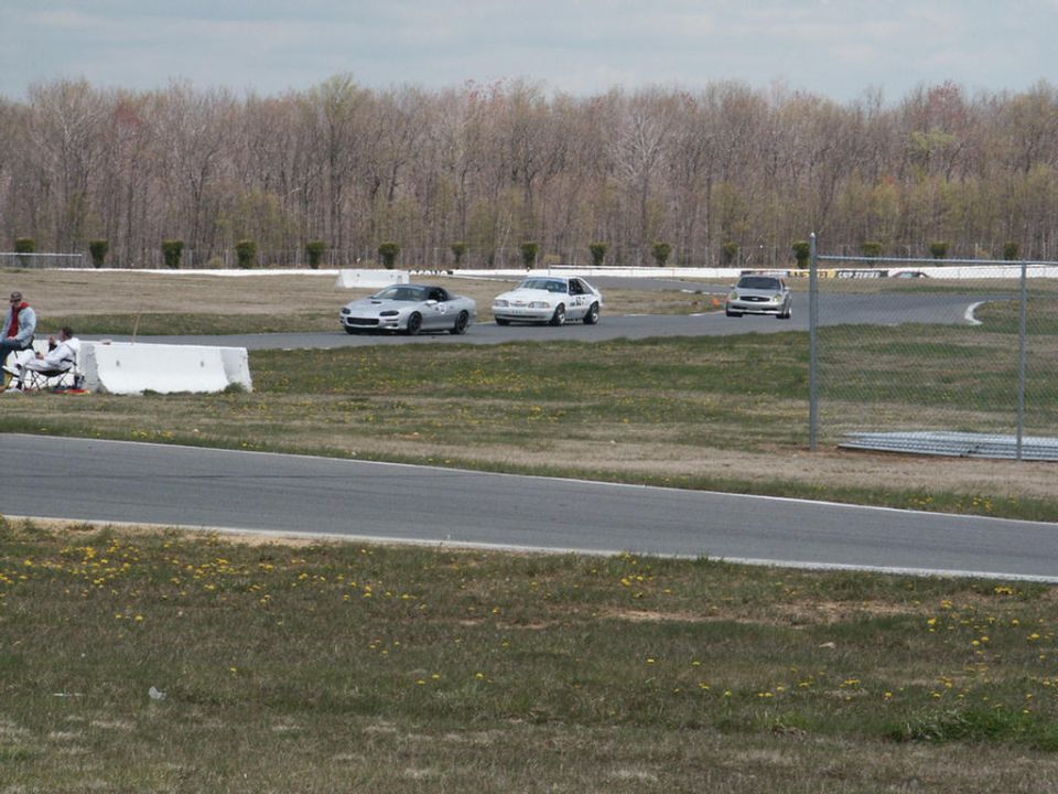 Silver sports car, white hatchback, and silver SUV on a race track