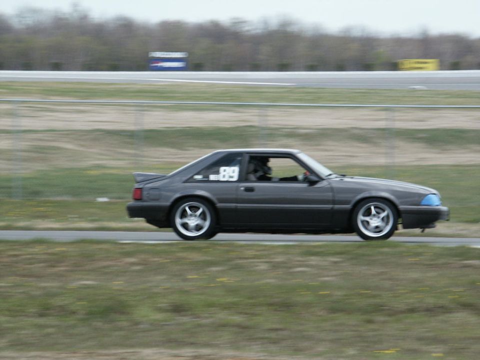 Gray coupe with racing number 89 on door, side view on track