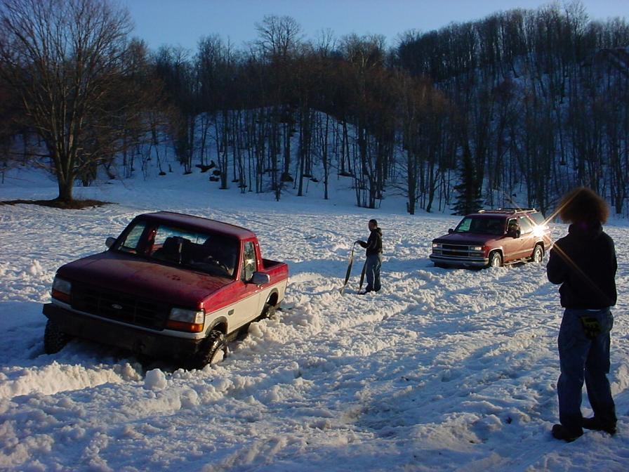Red and white pickup truck stuck in snow, 3q-front view. 1995 model
