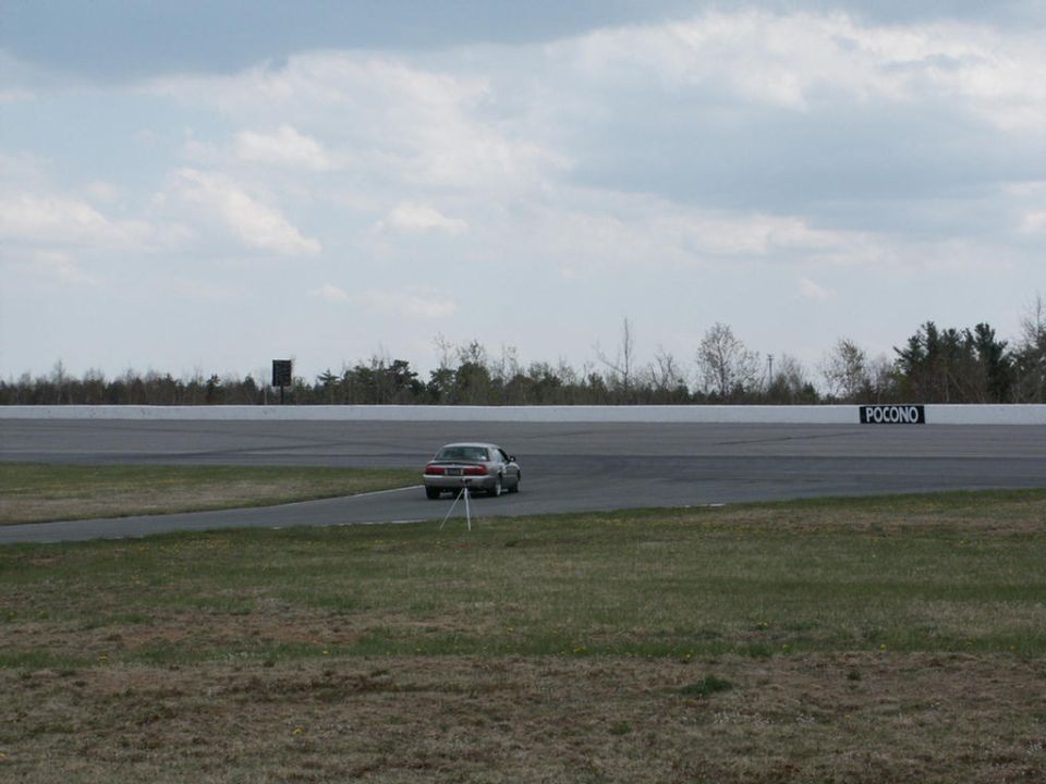 2001 Mercury Grand Marquis on a racetrack with a tripod in front of it