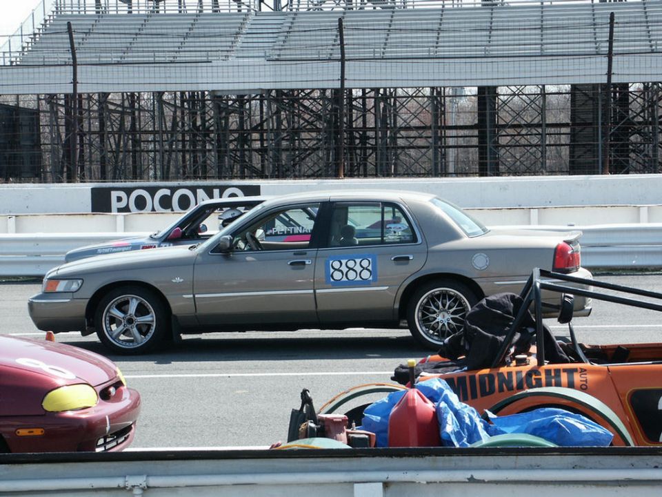 Tan 2001 Mercury Grand Marquis with racing number 888 on its side