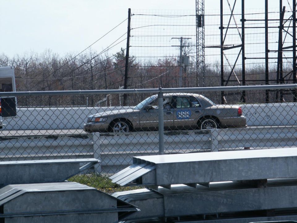 Tan sedan with blue racing numbers '888' on the door, seen from the side at a racetrack