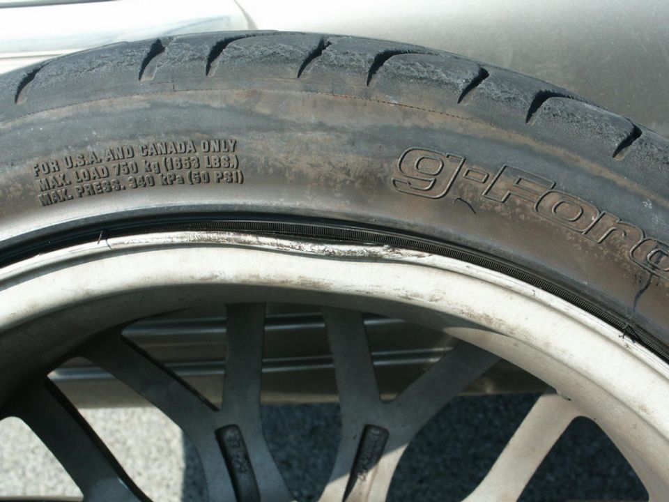 Close-up of a worn tire with 'G-Force' branding on a custom rim