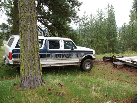 1994 Ford C-350 (Centurion Conversions) - A modified Ford SUV with a custom rear section is parked in a wooded area.
