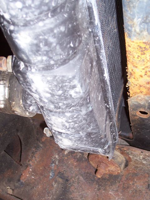 1978 Ford Bronco - This close-up shows a radiator hose and its connection point, with visible residue and rust on nearby components.