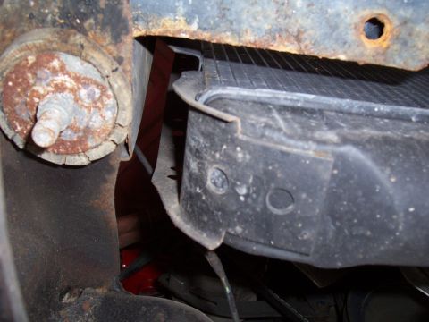 1978 Ford Bronco - Close-up of a corroded body mount and radiator bracket.