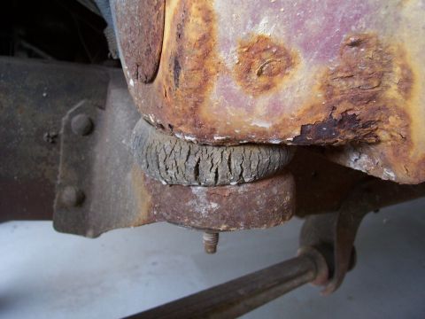1978 Ford Bronco - Close-up of a corroded vehicle body mount with a deteriorated rubber bushing.