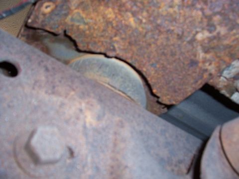 1978 Ford Bronco - Close-up view of heavily rusted vehicle frame and suspension parts.