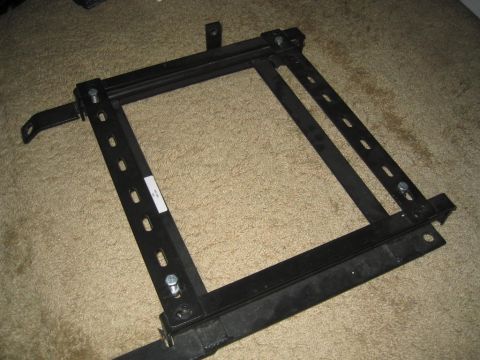 1993 Ford Probe - A black metal seat bracket is shown on a carpeted floor.