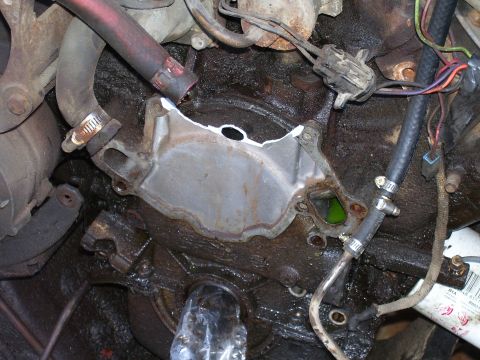 1984 Ford Bronco - This image shows a close-up view of an engine block, focusing on hoses and wiring connected wiring, with a metal plate removed.