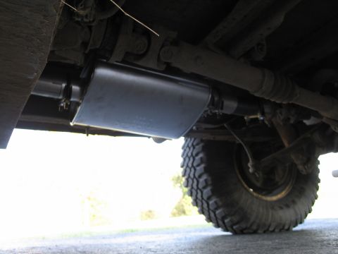 1995 Ford Bronco - Underside view of a vehicle's exhaust system and large tire.