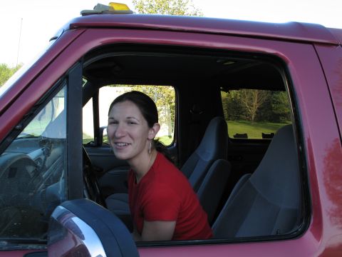 1995 Ford Bronco - A woman sits in the driver's seat of a red 1995 Ford Bronco.