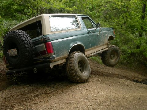 1990 Ford Bronco - This lifted Ford Bronco navigates a challenging off-road course with one wheel off the ground.