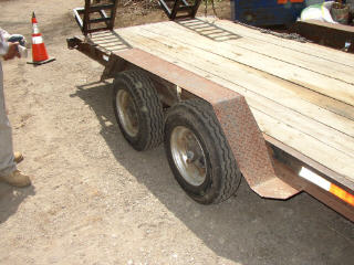 1995 Ford Bronco - A trailer with dual wheels and a wooden deck is shown from the side.