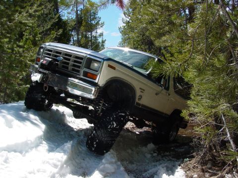 1986 Ford Bronco - This lifted 1986 Ford Bronco tackles a snowy trail with its large off-road tires.