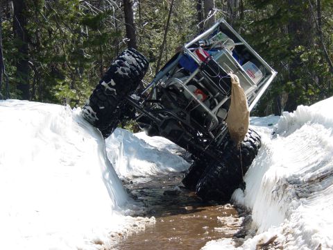 1986 Ford Bronco - This off-road vehicle appears to be stuck in a snowbank next to a stream.