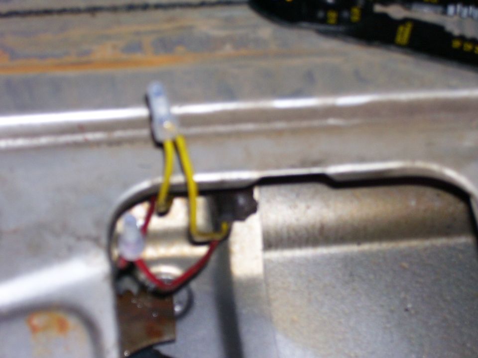 Close-up of a wiring harness clip with yellow and red wires