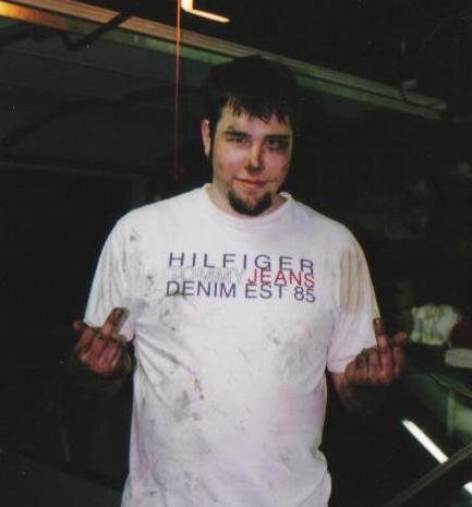 1994 Ford Probe - A man in a garage gives the finger while wearing a stained t-shirt.