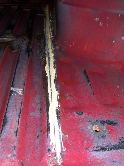 1978 Ford Bronco - Interior floor seam with sealant applied, showing some rust and wear.
