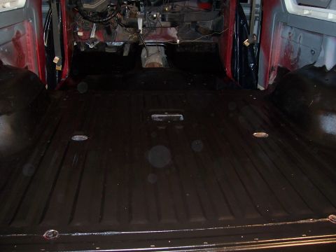 1978 Ford Bronco - The interior of a vehicle shows a freshly painted black floor and the exposed dashboard area, indicating a restoration or modification proj…