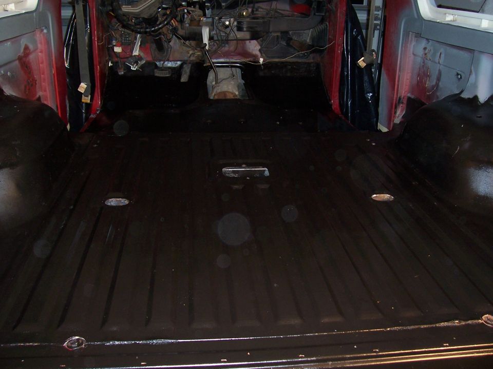 Interior view of vehicle with black floor and exposed dashboard components