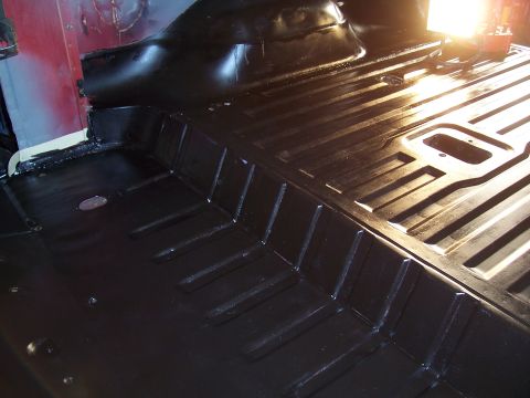 1978 Ford Bronco - The interior floor of a vehicle shows a ribbed texture and raised sections, painted black.