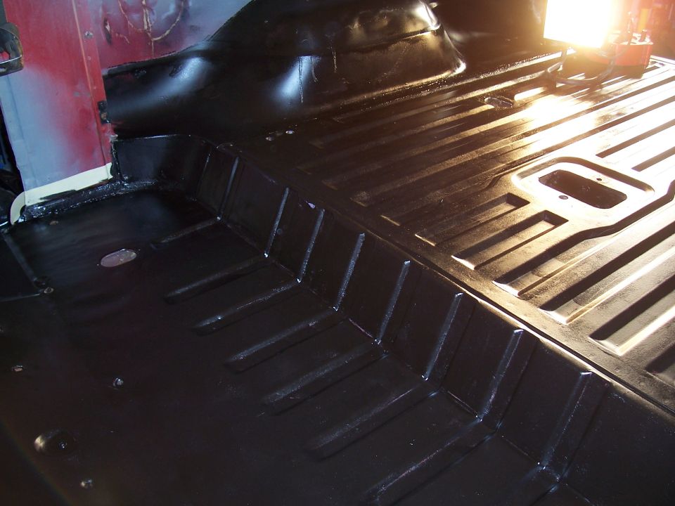 Black painted vehicle floor with ribbed texture and raised sections