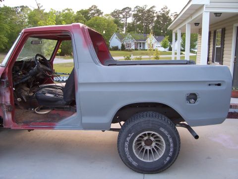 1978 Ford Bronco - This 1978 Ford Bronco is undergoing restoration, showing its side profile with primer gray body panels and a red roof.