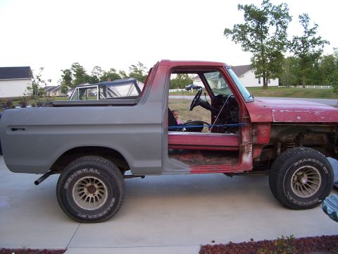 1978 Ford Bronco - Side view of a 1978 Ford Bronco undergoing restoration, doors off and primer applied to the rear.