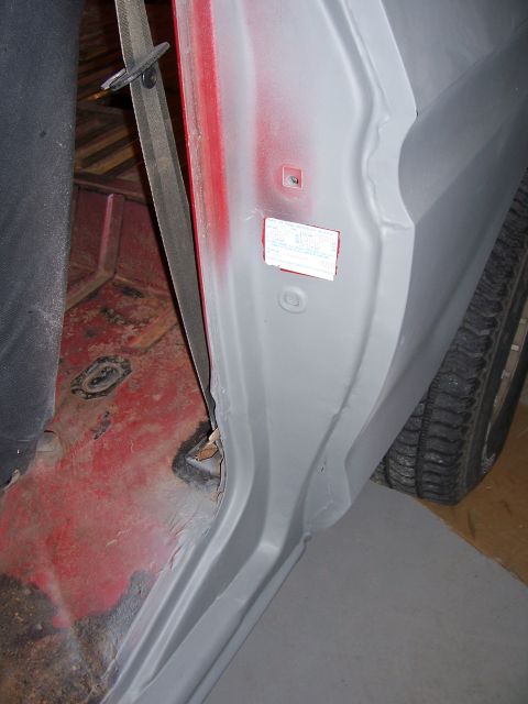 1978 Ford Bronco - Close-up view of a vehicle's interior door jamb, revealing a sticker and the underlying metalwork.