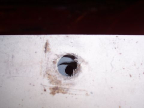 1978 Ford Bronco - A close-up view shows a drilled hole on a white surface, with a visible logo at the bottom right.