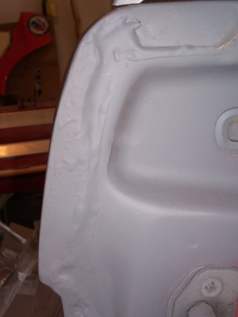 1978 Ford Bronco - Close-up view of a primer-coated fender section, showing its contours and a mounting point.