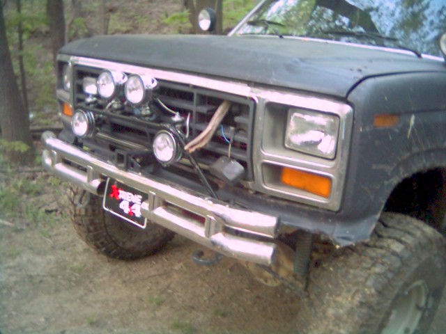 Dark colored truck front end with chrome bumper, grille, and quad headlights. License plate reads 'EXTREME 44'