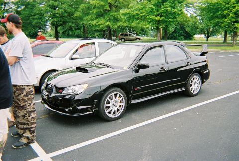 1991 Ford Probe - A black sedan with a prominent rear spoiler and hood scoop is parked in a lot.