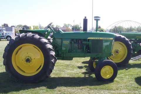 1994 Ford F-150 - A green John Deere 4020 Diesel tractor is shown from the side, with another tractor in the background.
