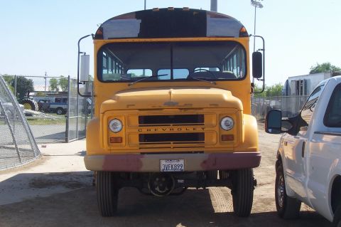 1994 Ford F-150 - Yellow Chevrolet bus parked next to a white pickup truck on a sunny day.