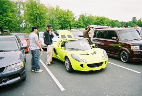 1991 Ford Probe - A lime green sports car is parked in a lot with its hood open, alongside other vehicles.