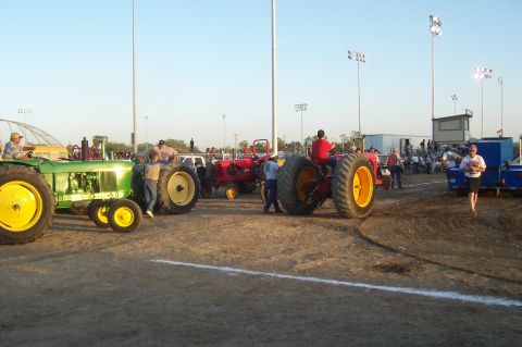 1994 Ford F-150 - A collection of tractors are on display at an outdoor event, with spectators observing.