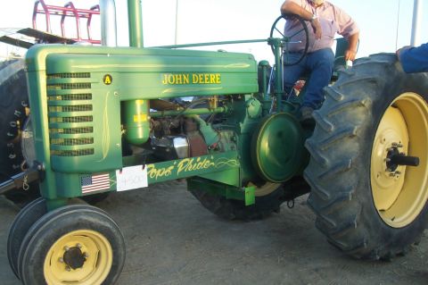 1994 Ford F-150 - A green John Deere tractor is parked outdoors, with a person sitting on the driver's seat.